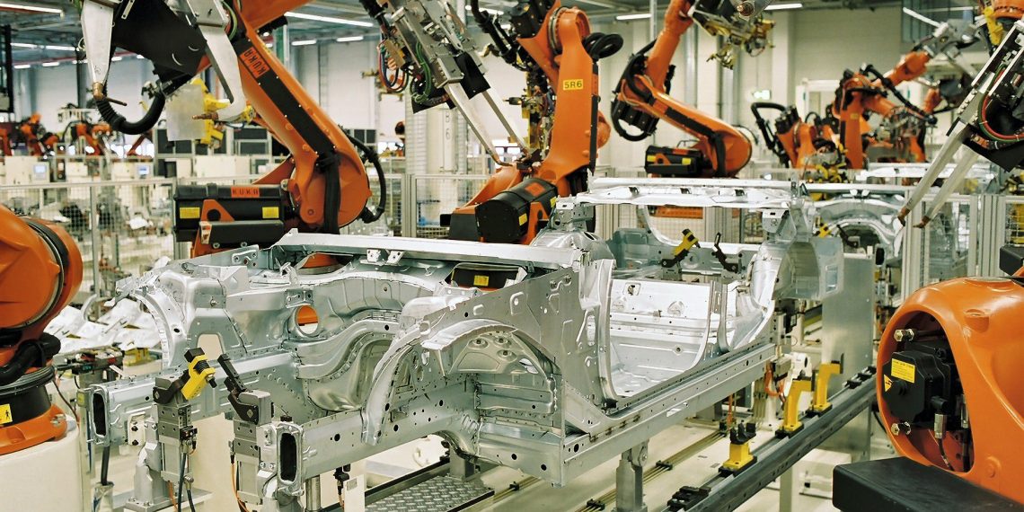 Workers assembling electric vehicles on a production line at a factory in Asia