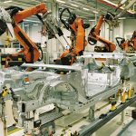 Workers assembling electric vehicles on a production line at a factory in Asia