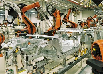 Workers assembling electric vehicles on a production line at a factory in Asia