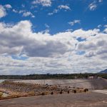 The Mekong river flowing past a hydropower dam with dry banks visible in the foreground